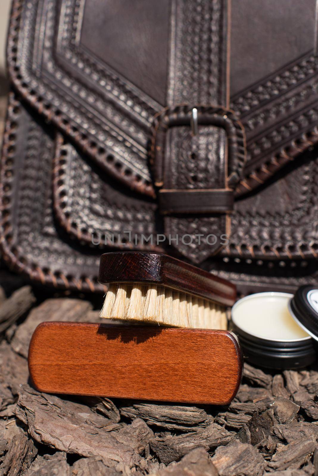 Wax and brush, leather maintenance concept. old genuine leather bag on a background. .