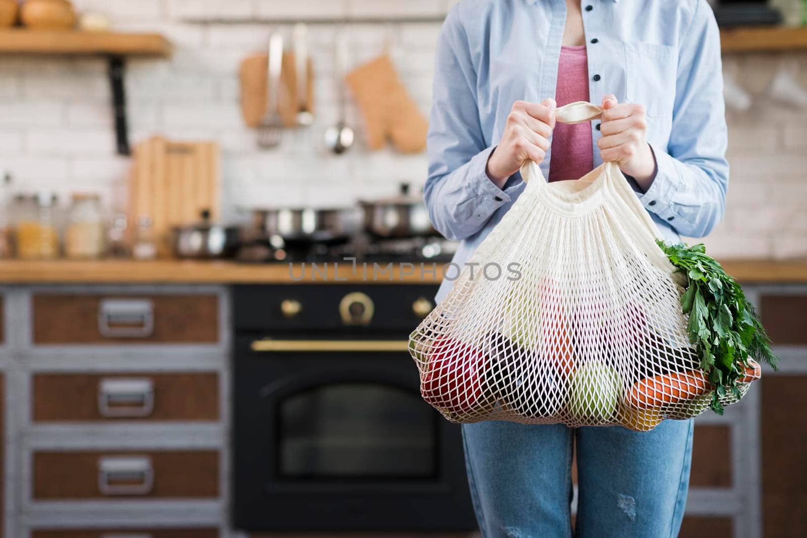adult woman holding reusable bag with organic vegetables by Zahard