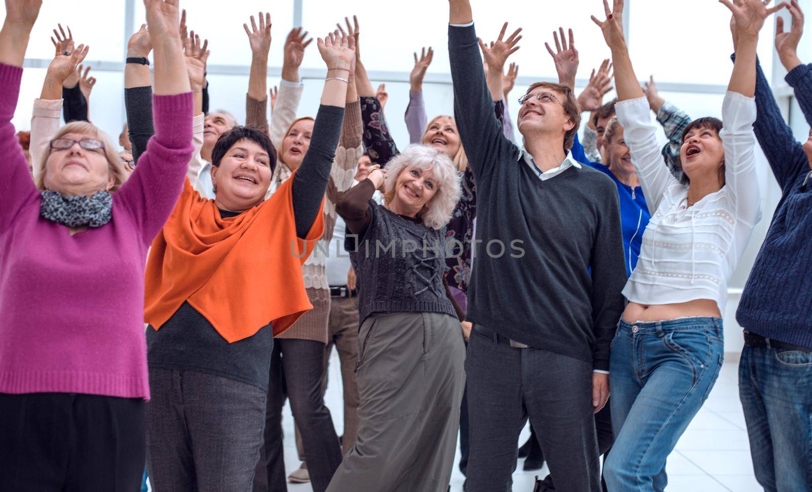 a group of elderly people are reaching up