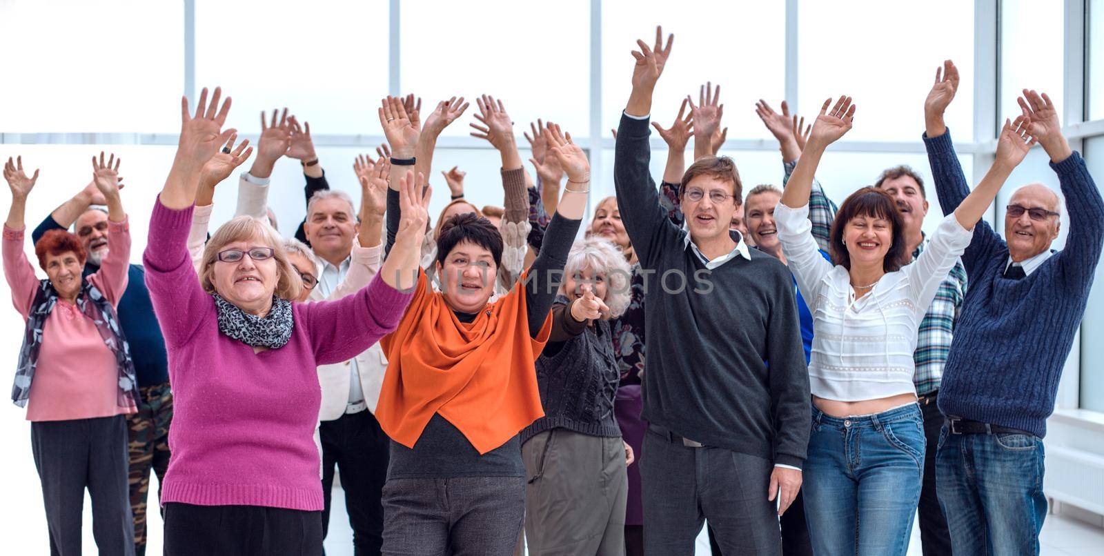 a group of elderly people are reaching up