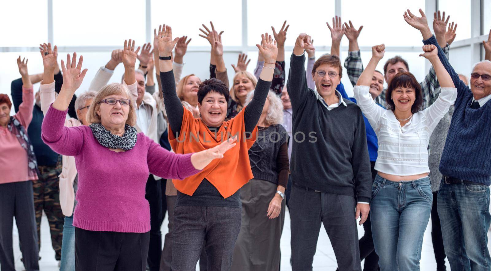 a group of elderly people are reaching up