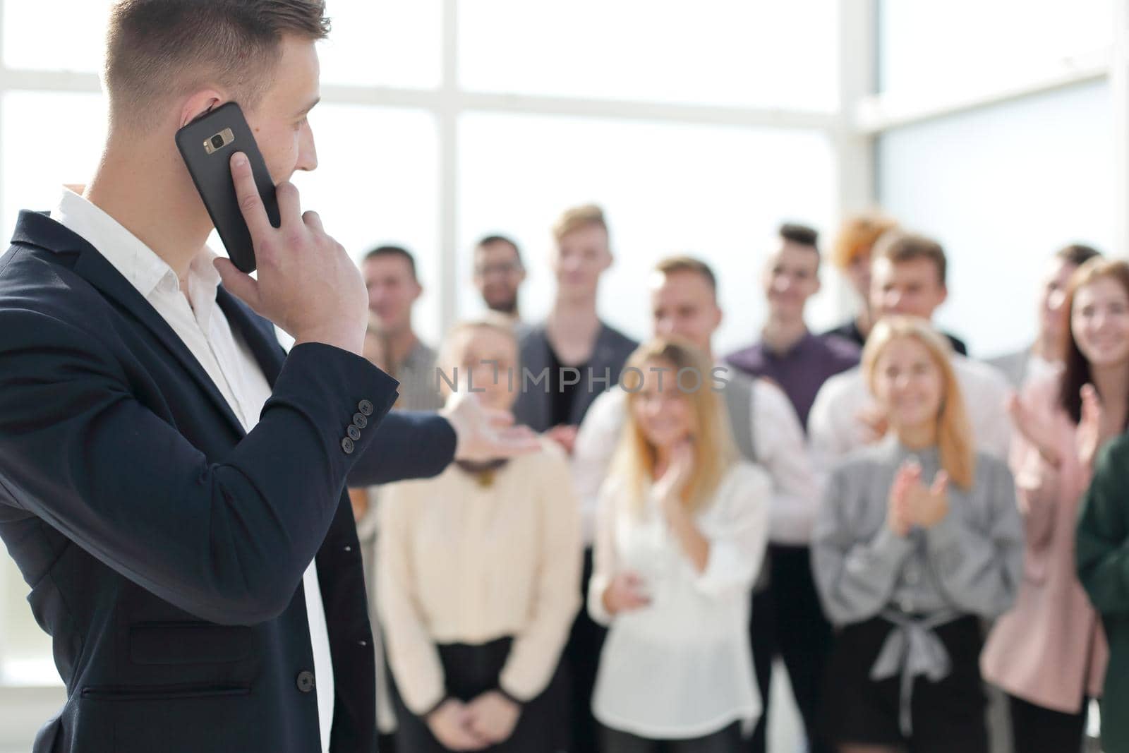 business man with smartphone pointing at a group of young people. photo with copy space