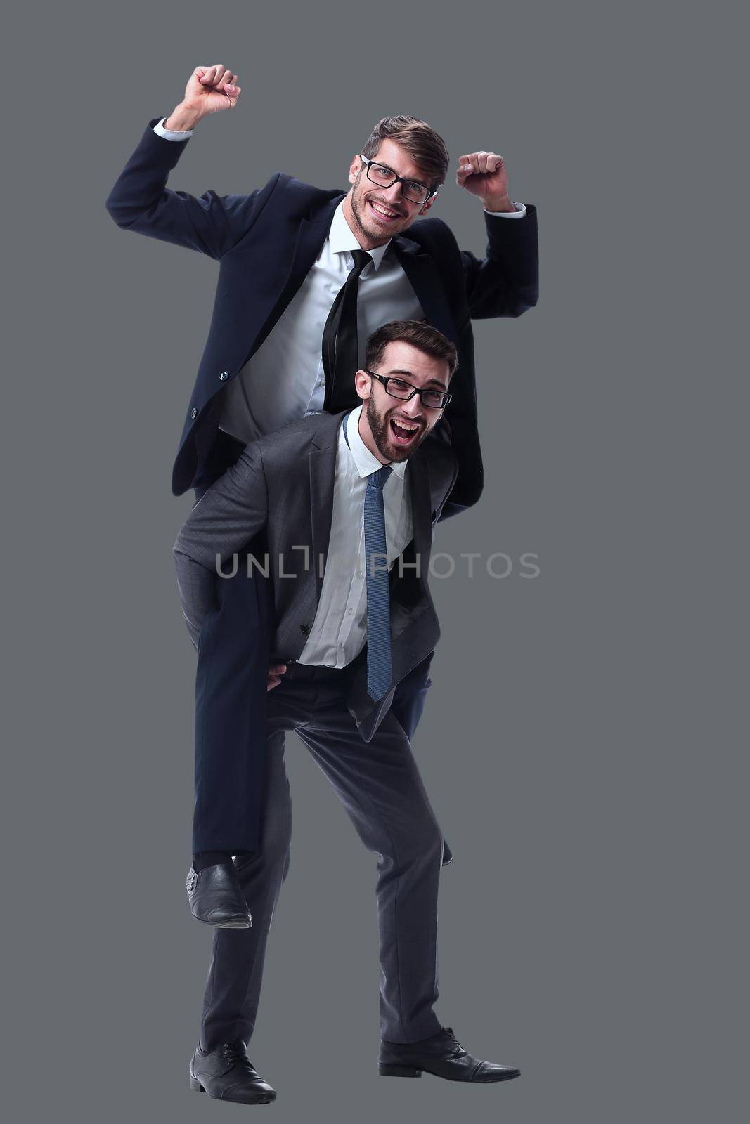 smiling businessman sitting on the back of his colleague . isolated on white background.