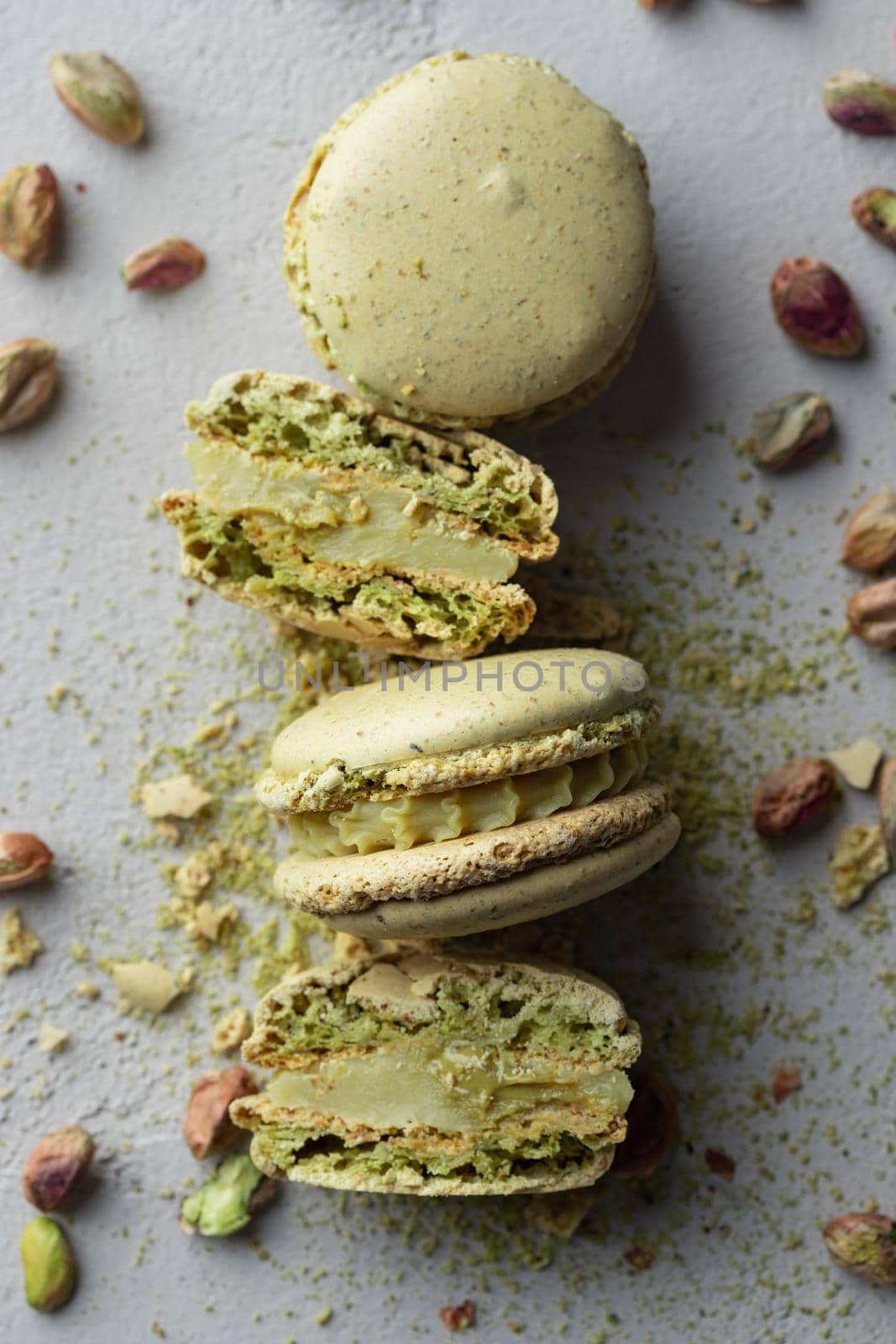 Pistachio flour and green macaroons on a gray background