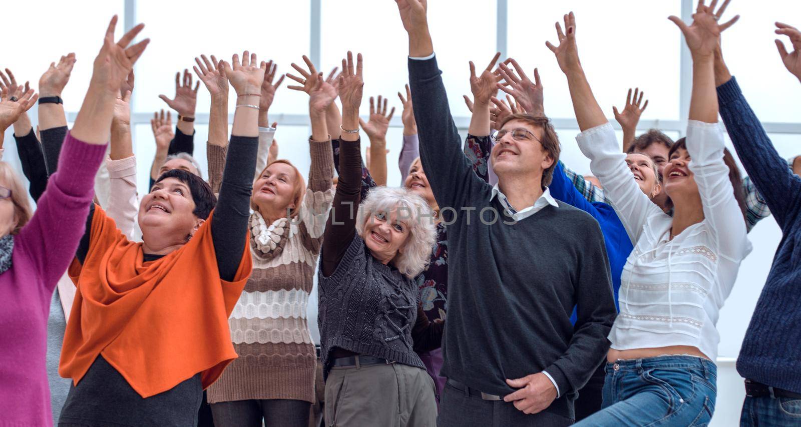 a group of elderly people are reaching up