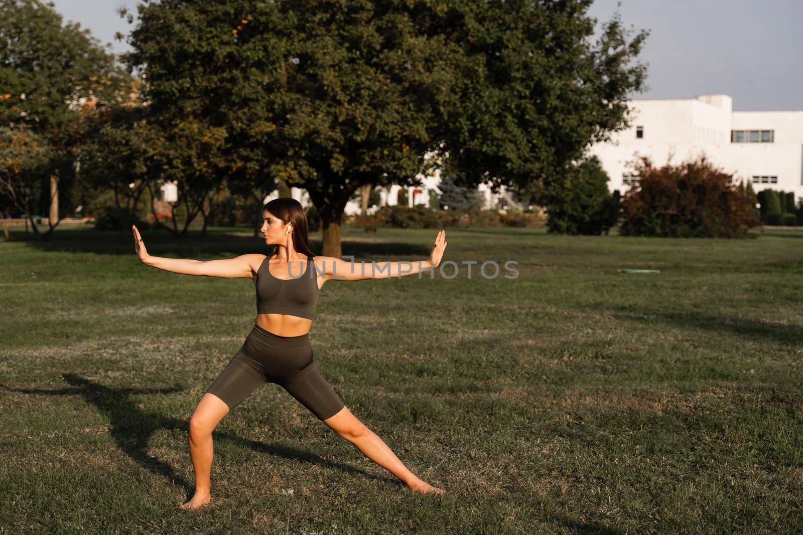 Hand movement of qigong meditation. Attractive girl meditating in the green park. by Rabizo