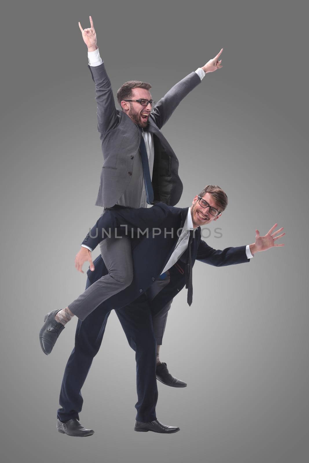 happy businessman carrying his colleague on the piggyback . isolated on white background