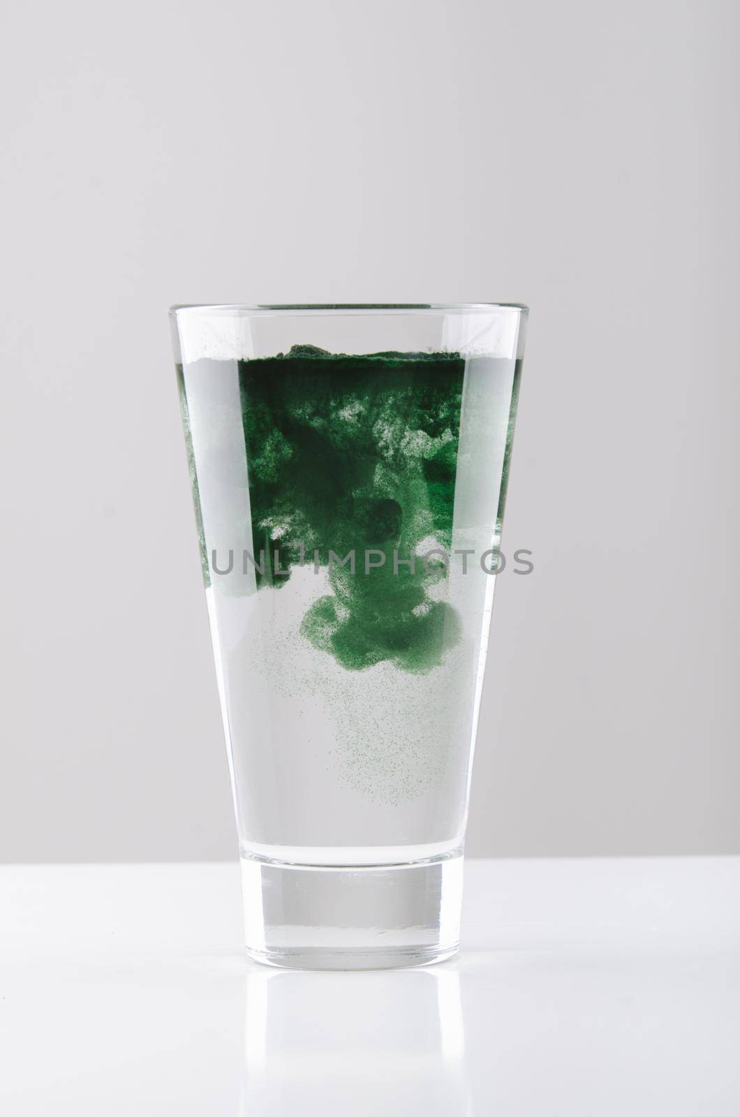 minimalist glass with water and spirulina powder. High quality photo