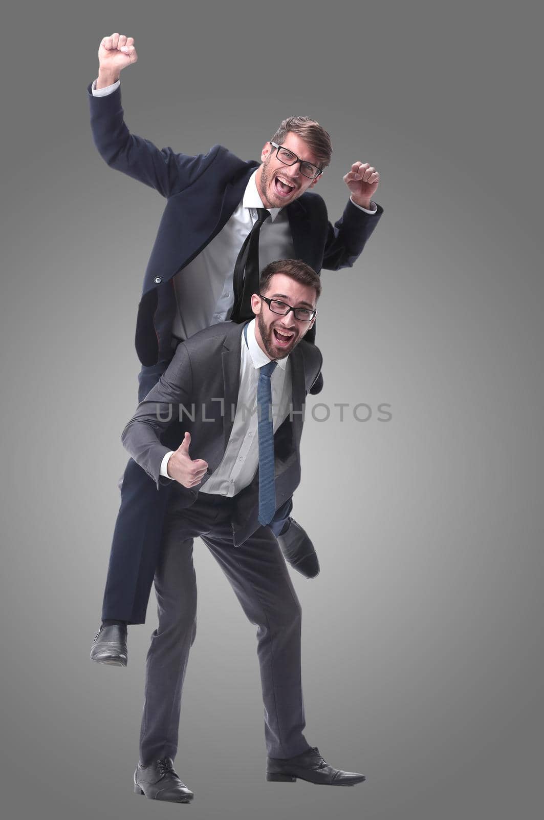 smiling businessman sitting on the back of his colleague . isolated on white background.