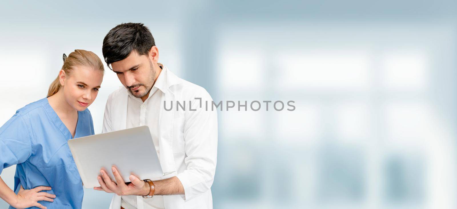 Doctors at hospital office working with another doctor. Healthcare and medical services.