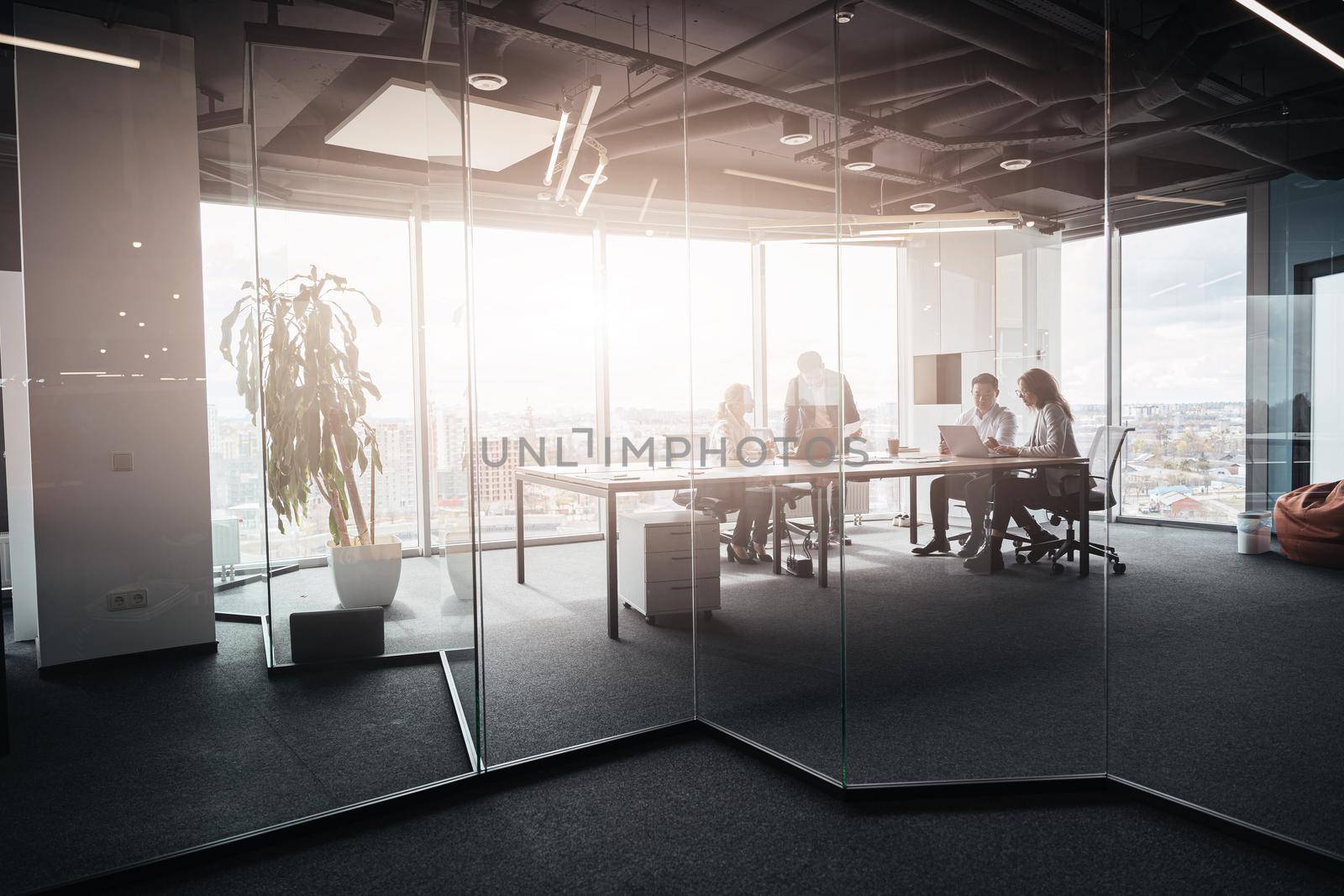 Team of businessmen communicating together in modern office with panoramic windows by Yaroslav_astakhov