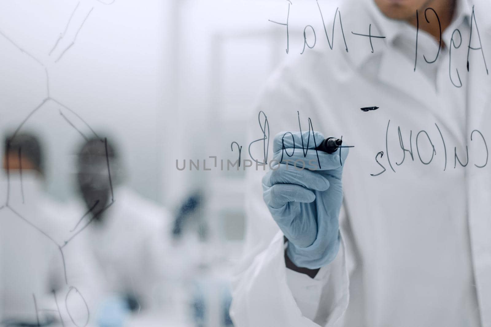 serious scientist writes a chemical formula on a glass Board.photo with copy space