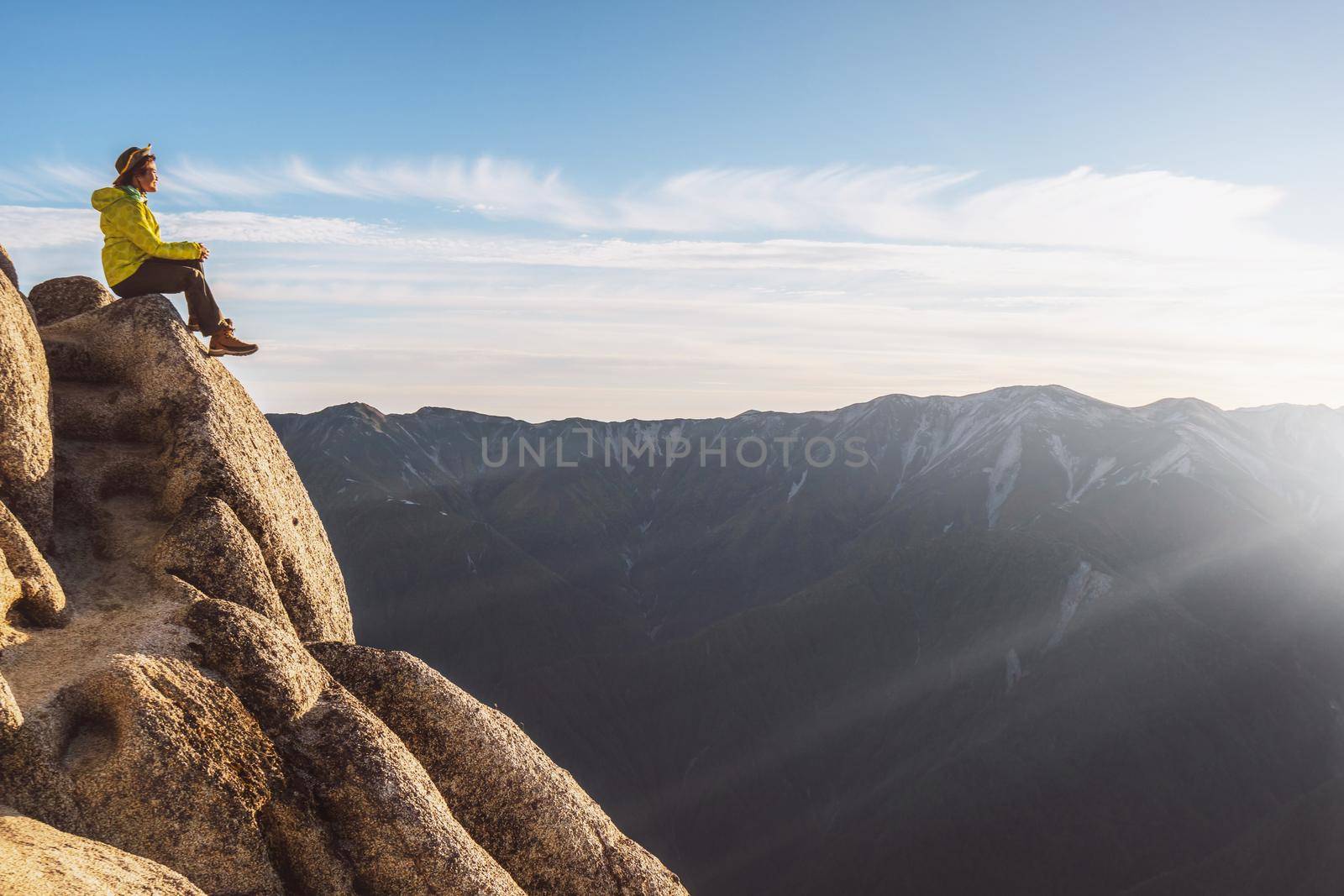 Epic adventure of brave and ambitious hiker trekking activity on wild cliff, pose with panoramic nature mountain landscape. Winner motivation and power discovery travel concept.