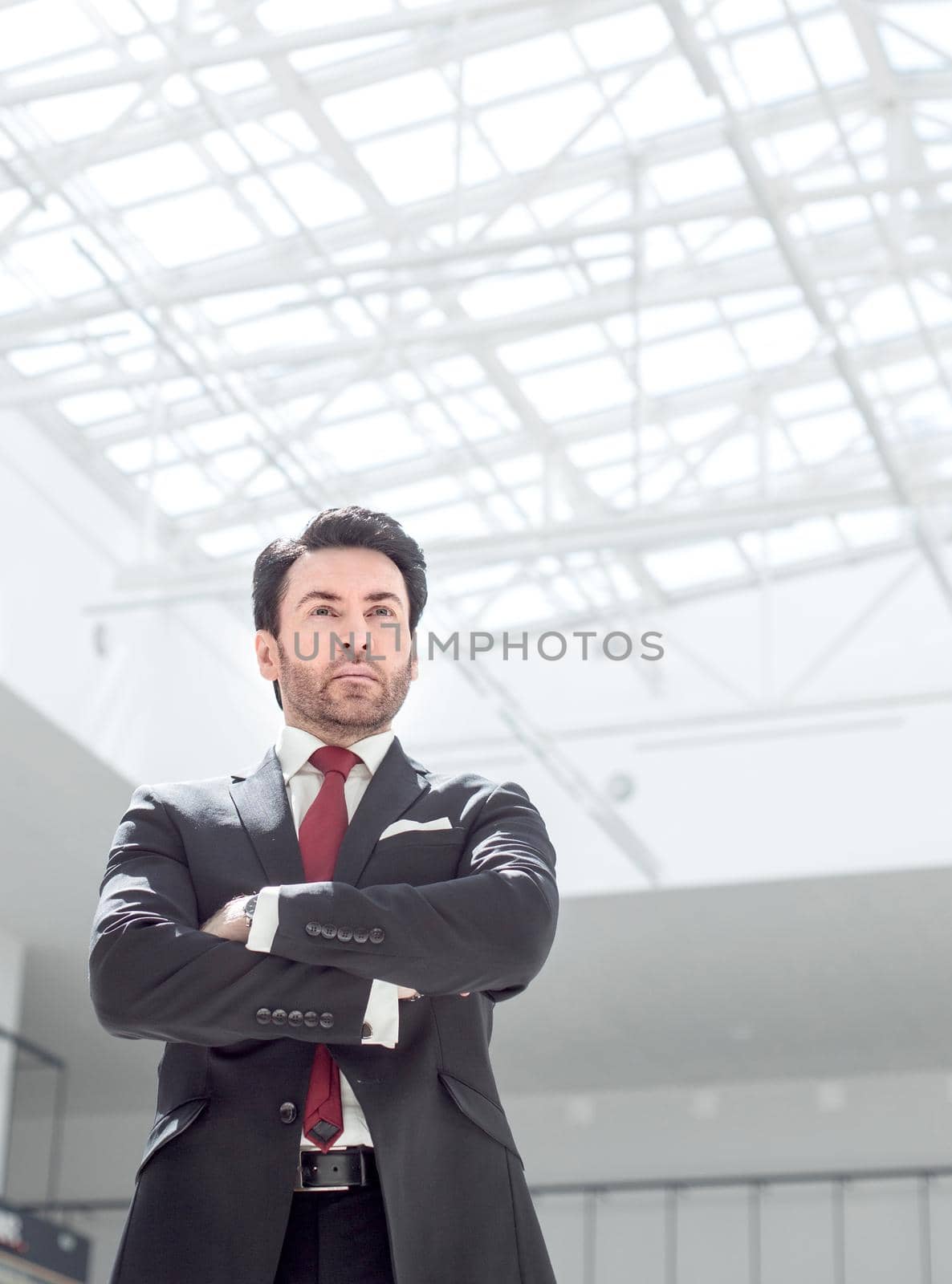 confident businessman standing in a spacious office by asdf