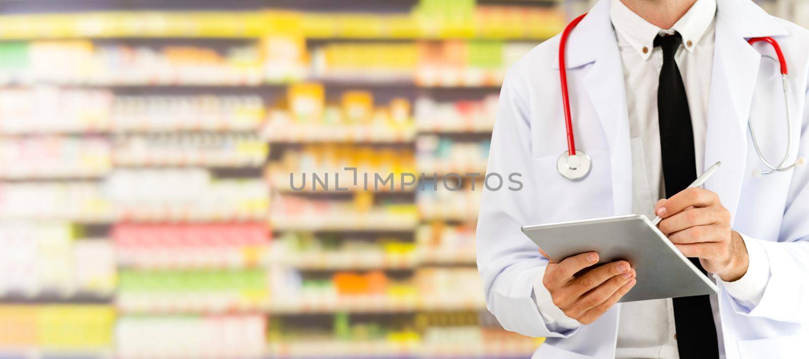 Pharmacist using tablet computer at the pharmacy. Medical healthcare and pharmaceutical staff service.