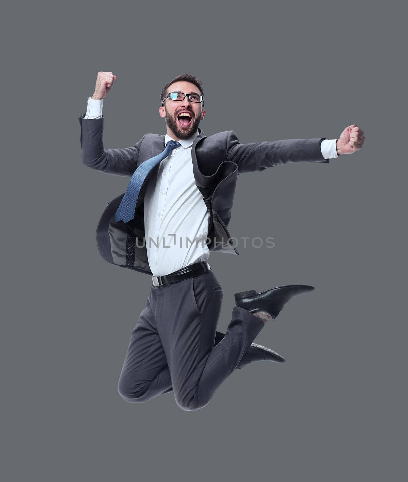 in full growth. happy young businessman. isolated on white background.