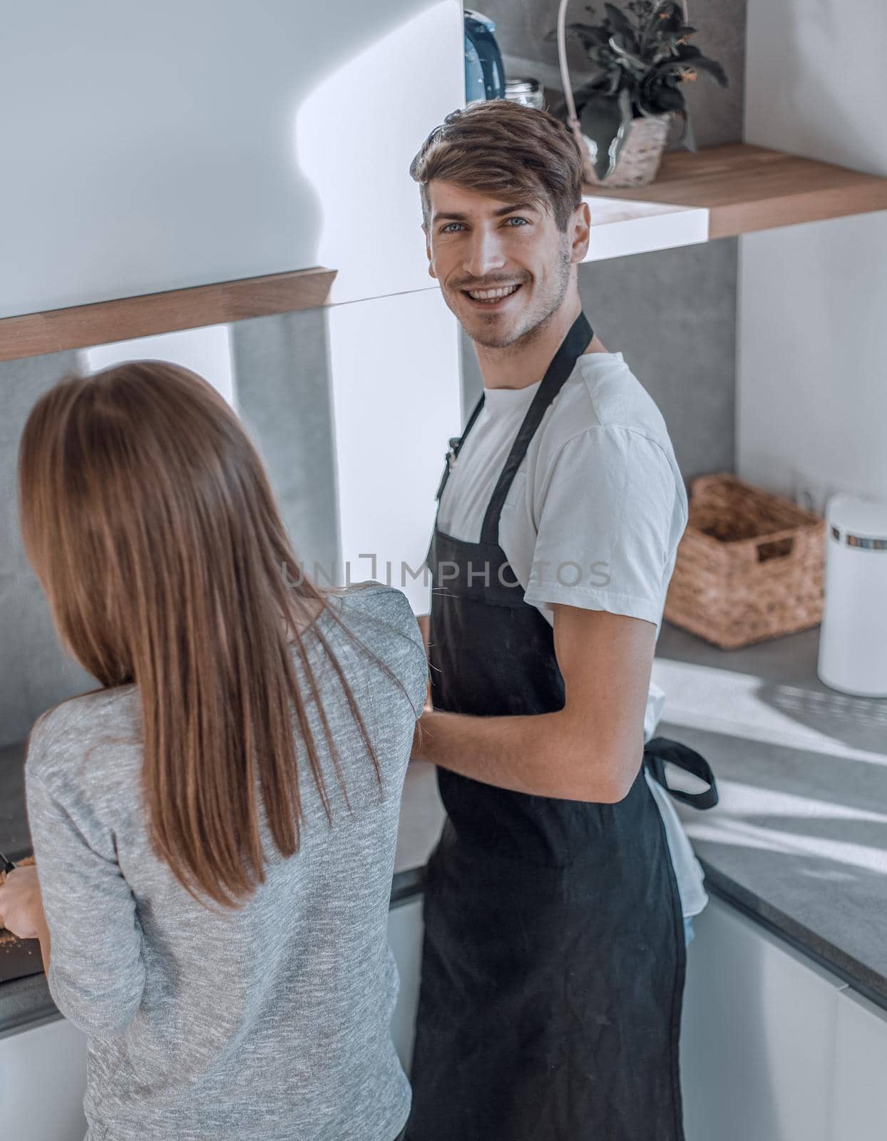 rear view.young couple standing near the kitchen table. photo with copy space