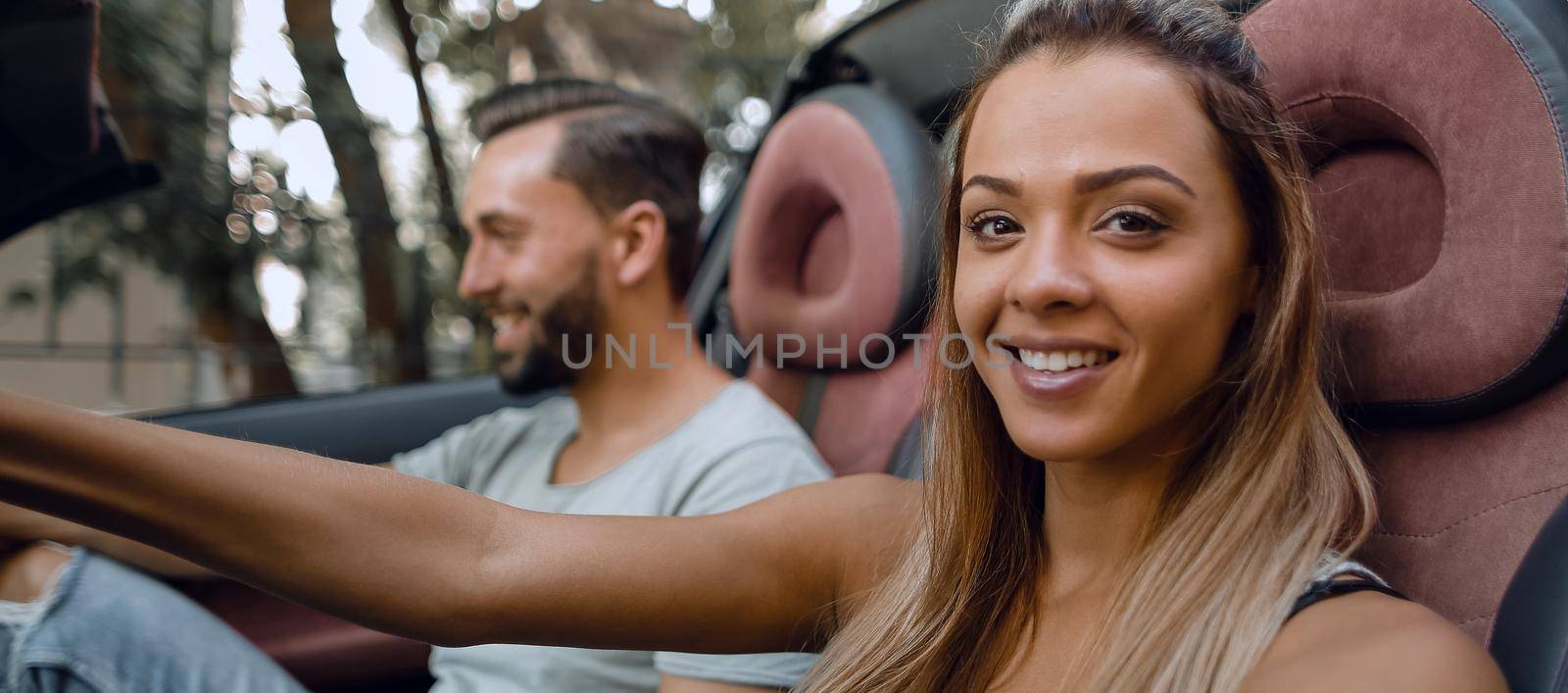 young woman driving a convertible car. by asdf