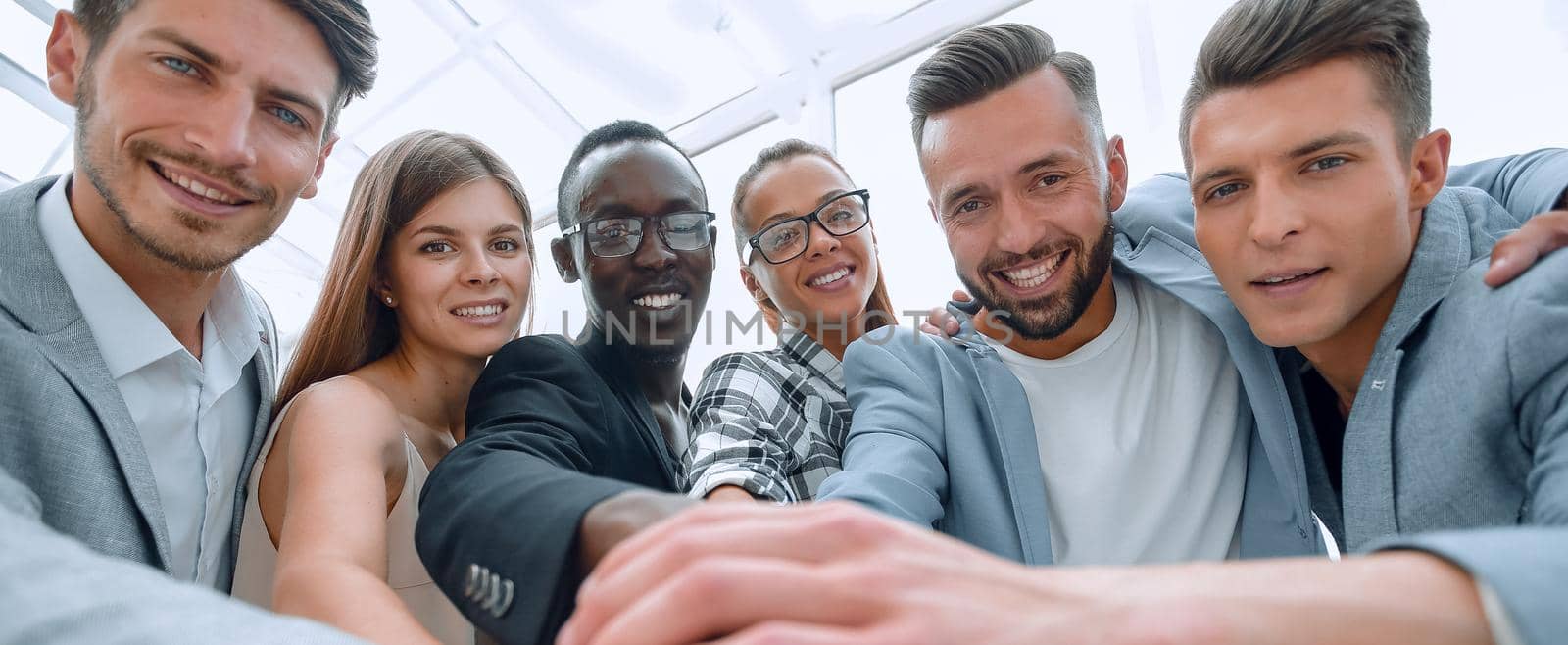 Mid section of businesspeople with hand stacked in office