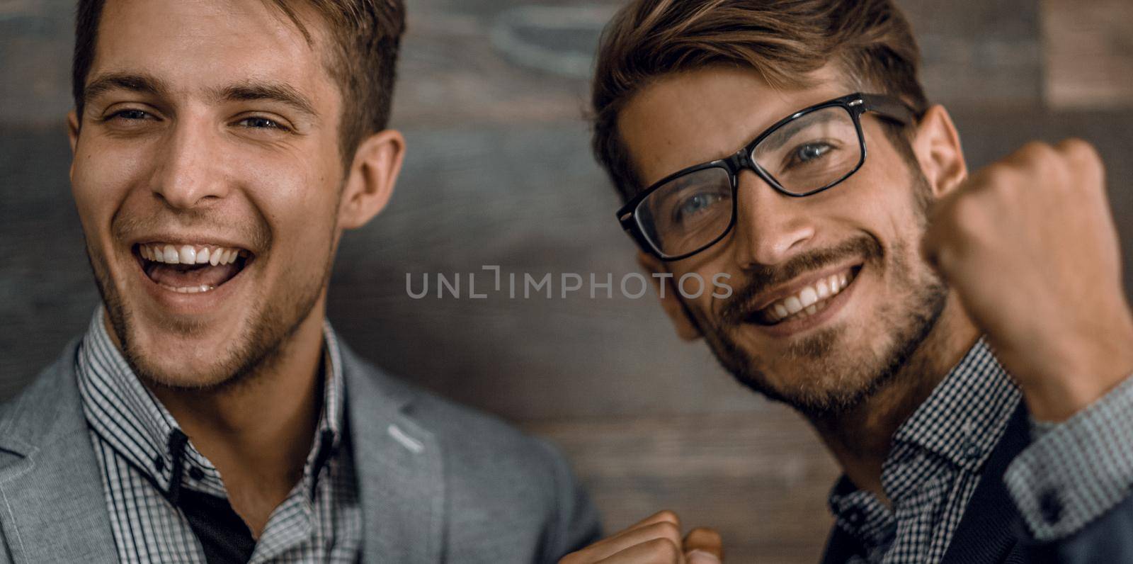 Two men having fun isolated over grey wall with copy space.