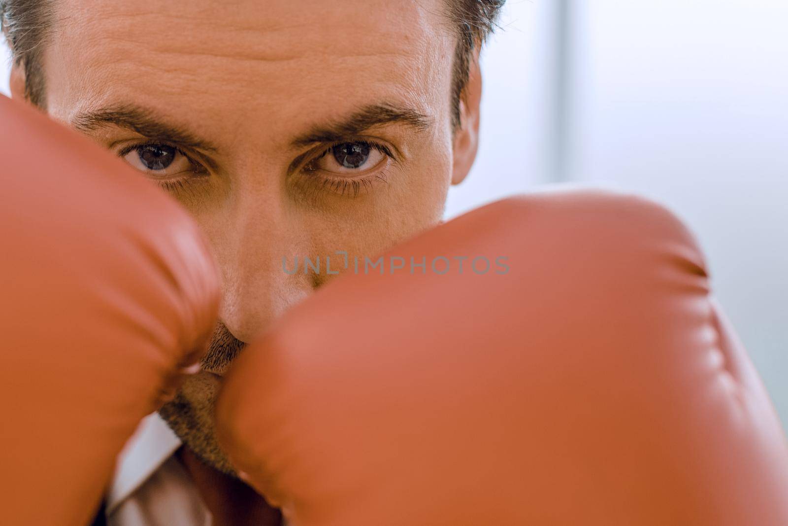 close up.businessman in Boxing gloves holding a punch.concept of competitiveness