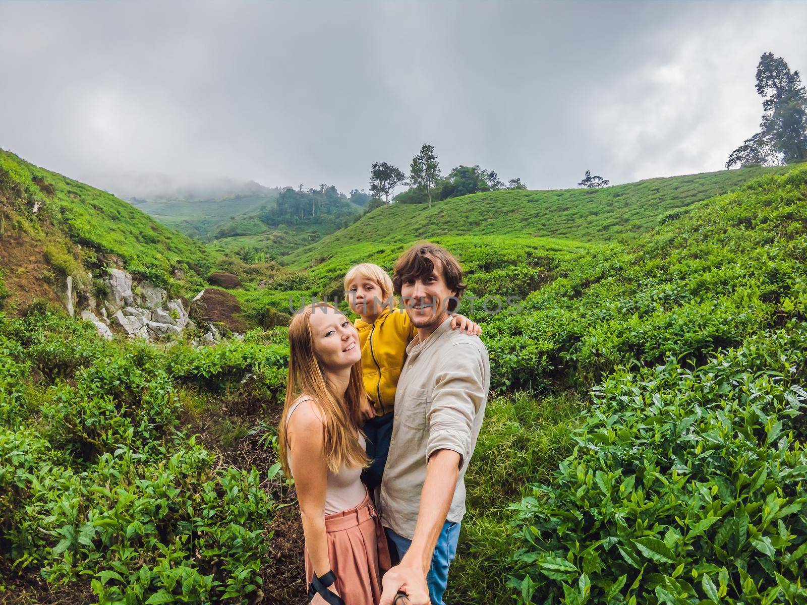 Mother, Father and son are traveling on a tea plantation in Malaysia. Traveling with children concept by galitskaya