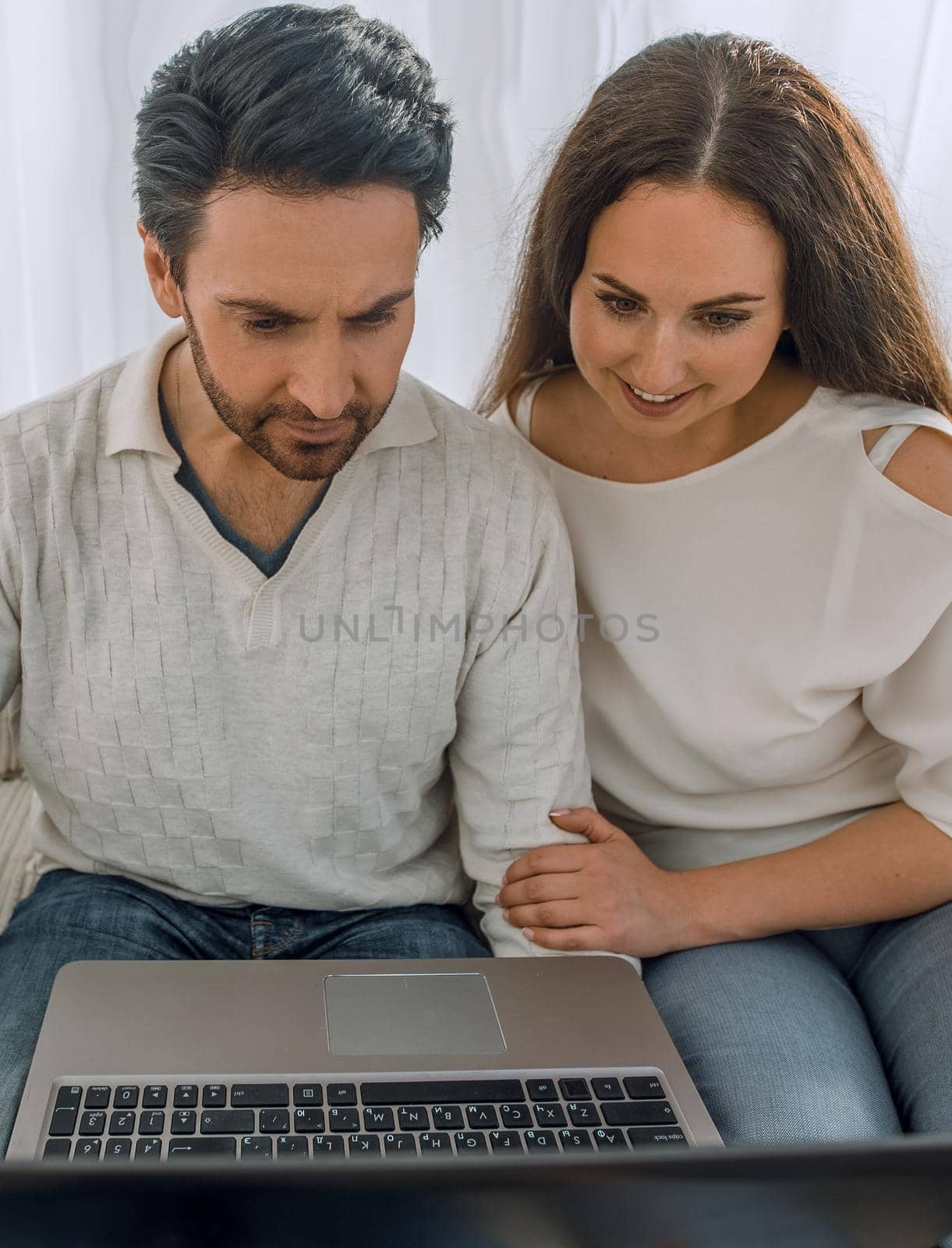 couple with laptop sitting in the living room on the sofa .photo with copy space