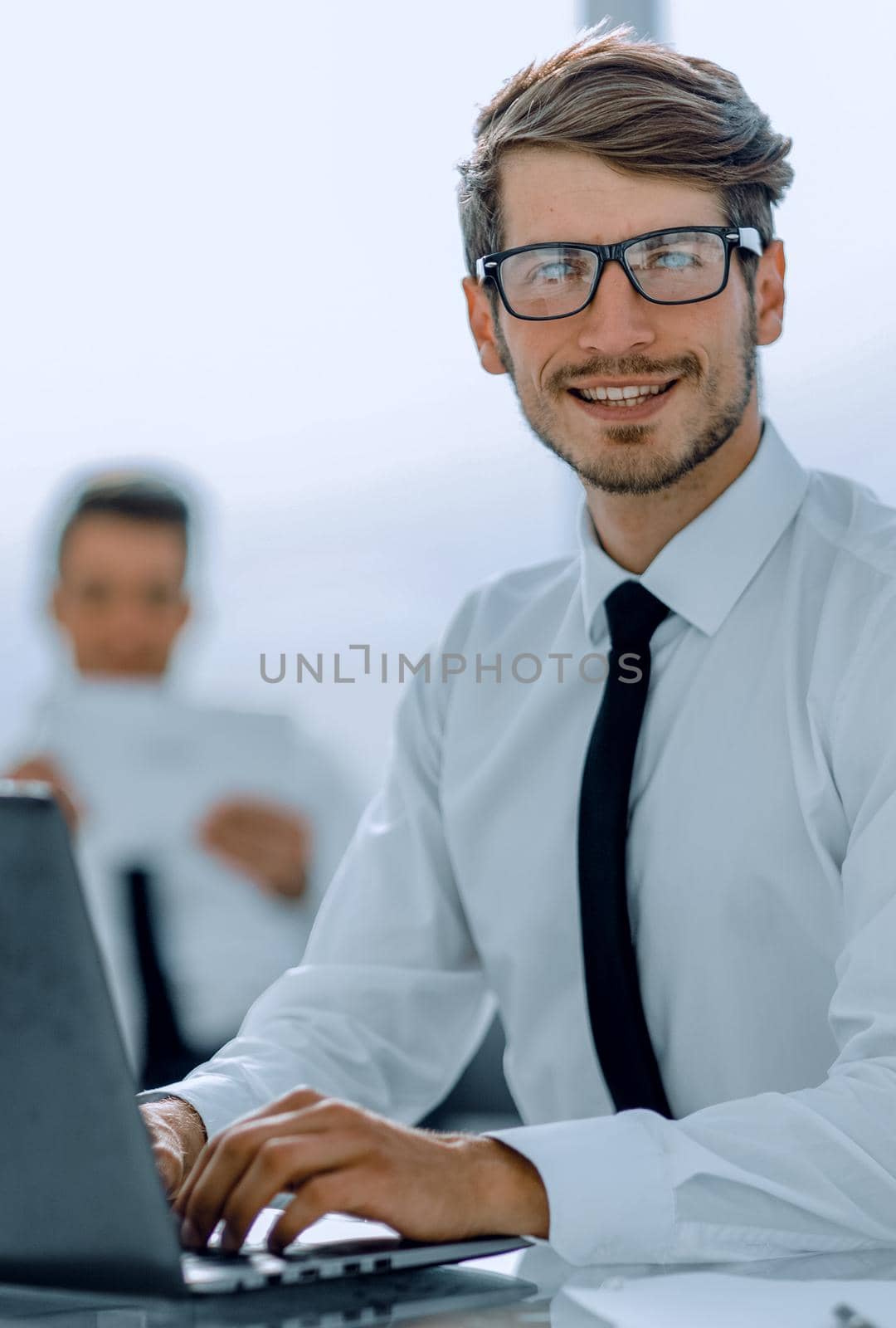 businessman working on laptop sitting at office desk looking at computer screen typing , using software application for business and education