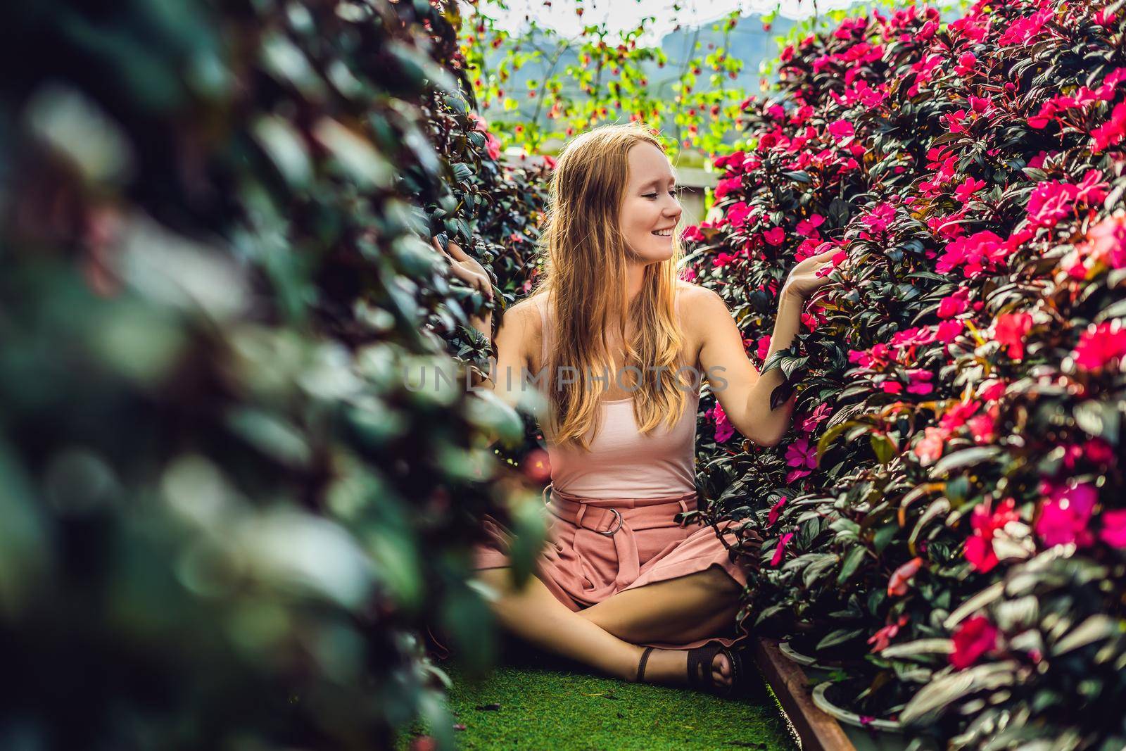 Young woman in a flower greenhouse. Bright tropical flowers. by galitskaya