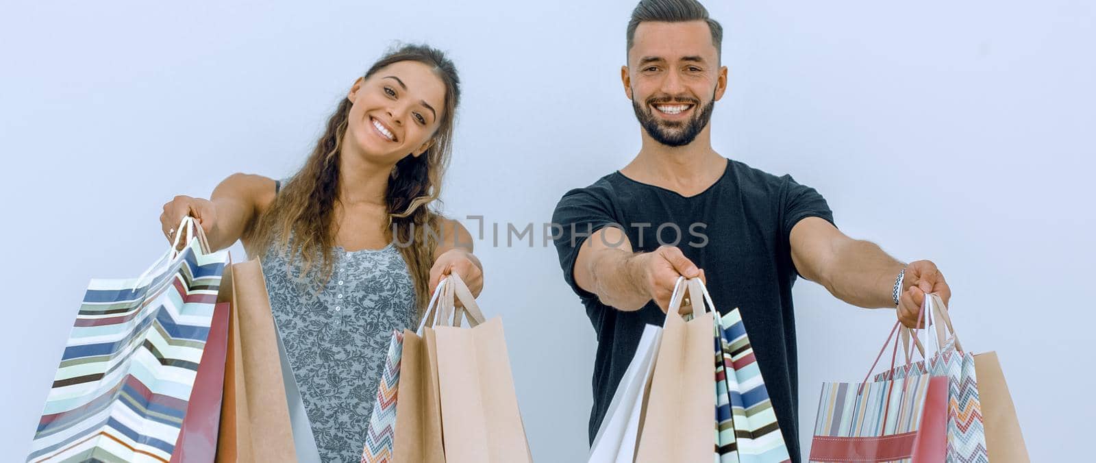 young couple shows shopping bags.isolated on white background