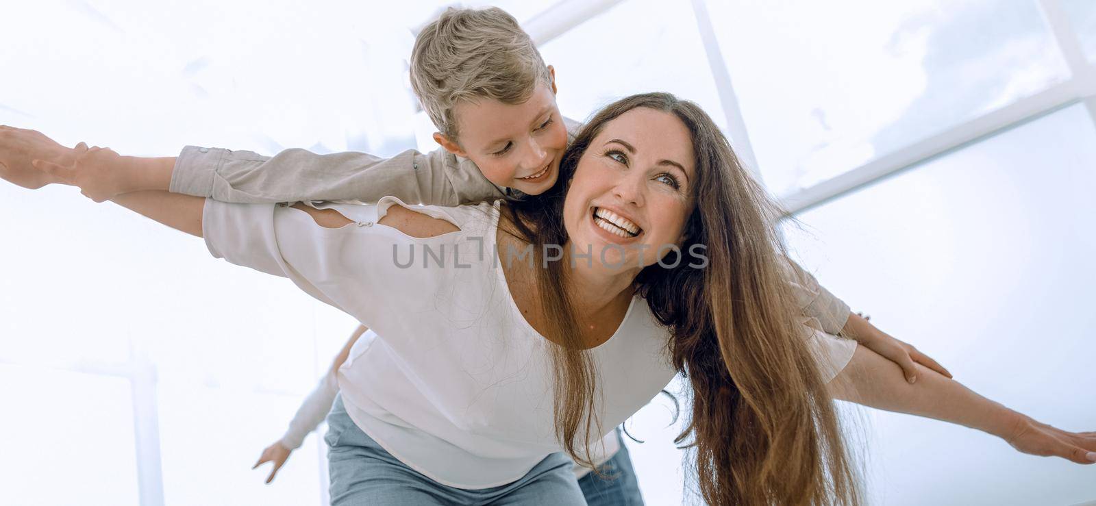 mother plays with her son in a spacious living room by asdf