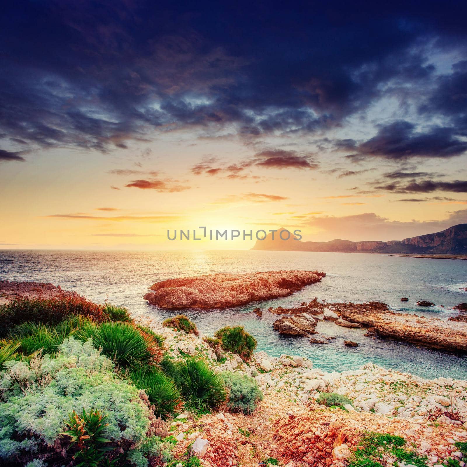 Fantastic view of the nature reserve Monte Cofano. Dramatic scene. Sunset over sea. Location cape San Vito. Sicilia, Italy, Europe. Mediterranean and Tyrrhenian sea.