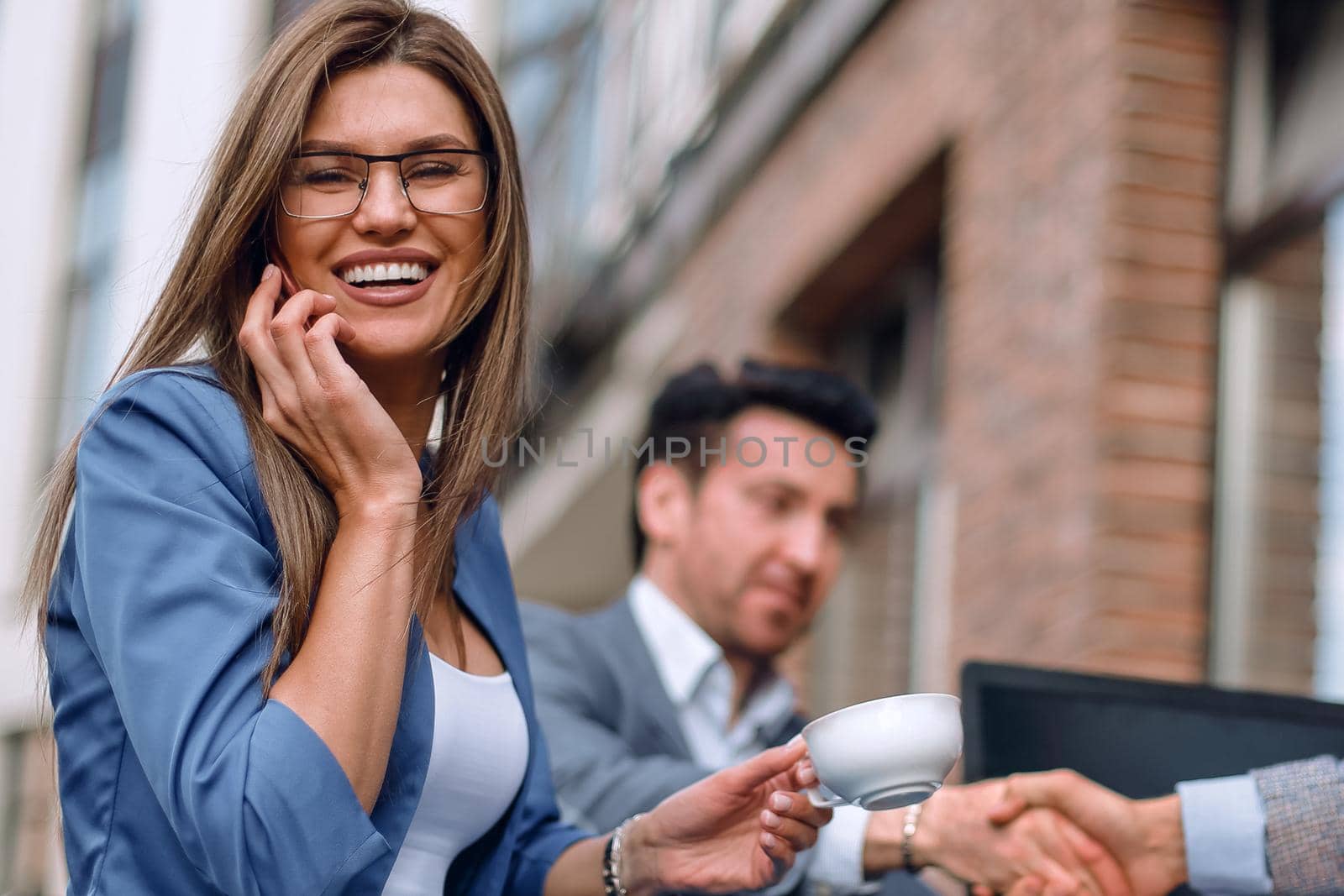 business woman talking on smartphone in street cafe by asdf