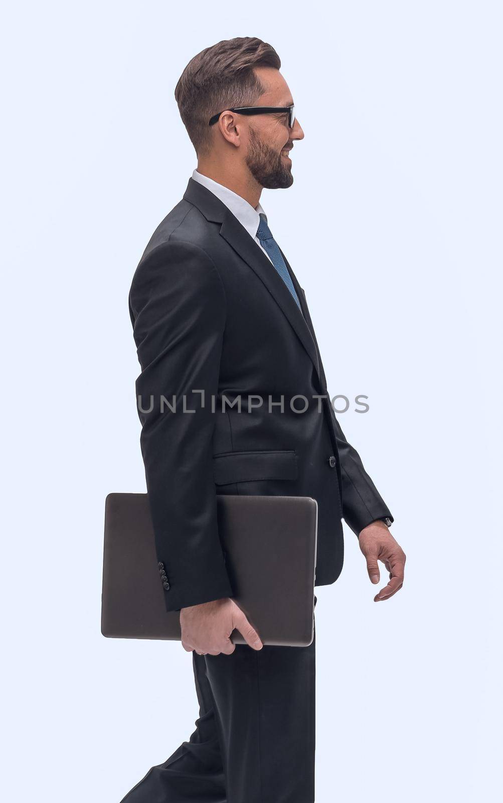 in full growth. successful businessman with laptop stepping forward. isolated on white background
