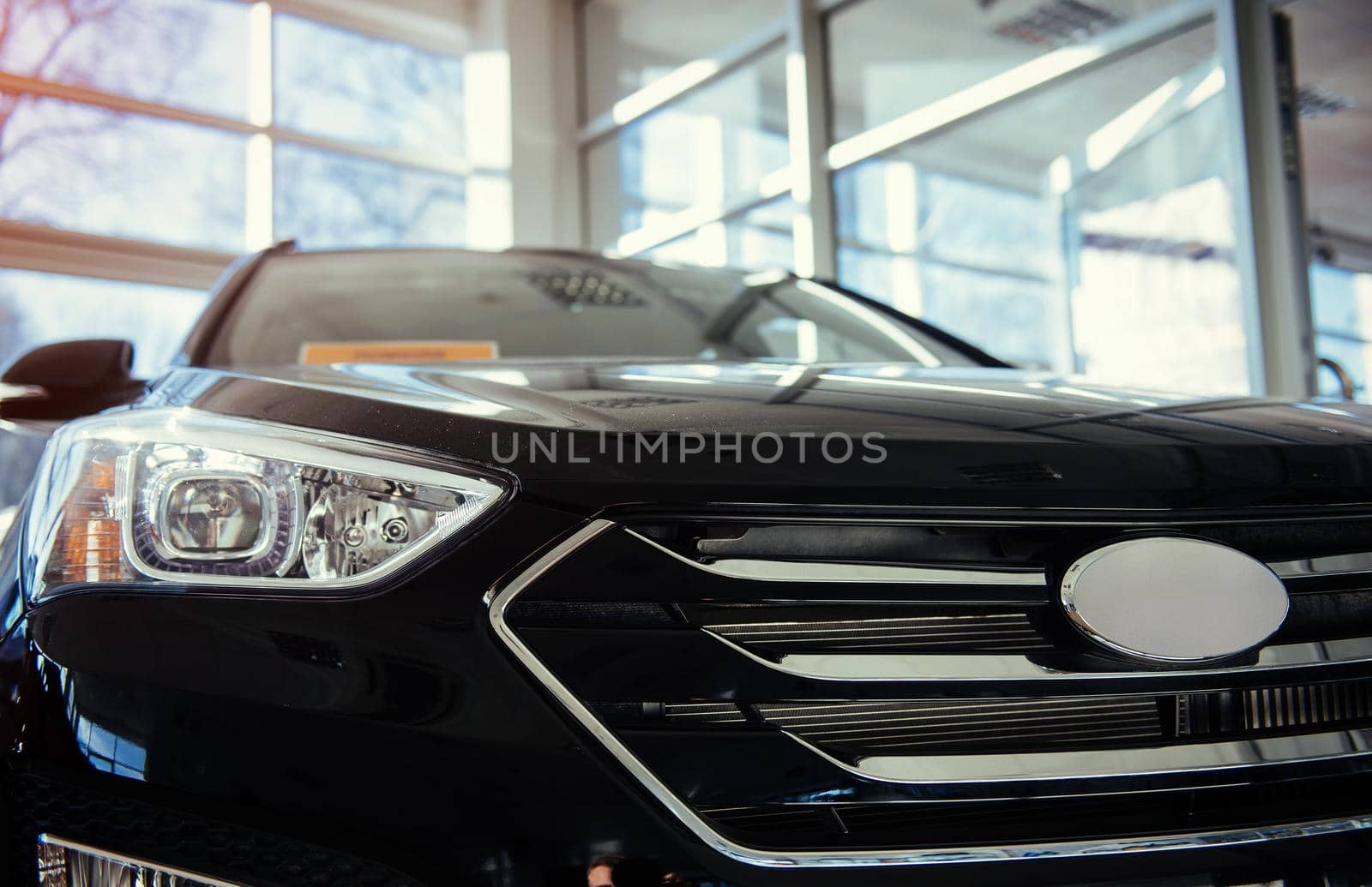 The headlights and the hood of a black sports car.