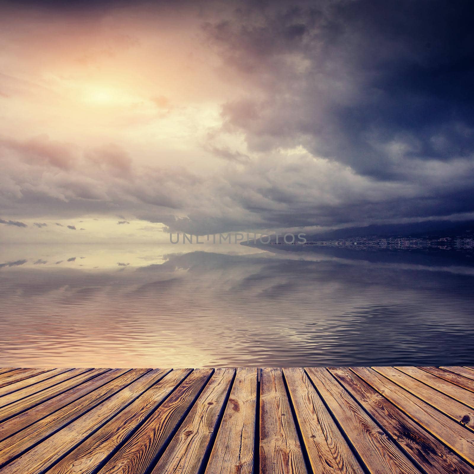 Beautiful sunset over sea with reflection in water, majestic clouds in the sky