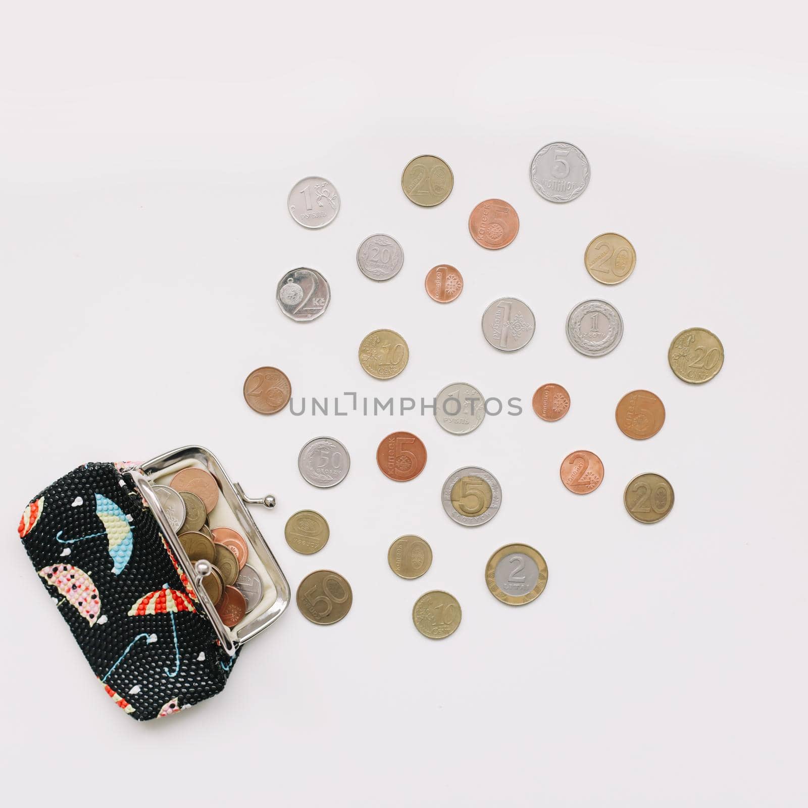 Open purse with different coins isolated on white background top view. Financial crisis, poverty, lack of money