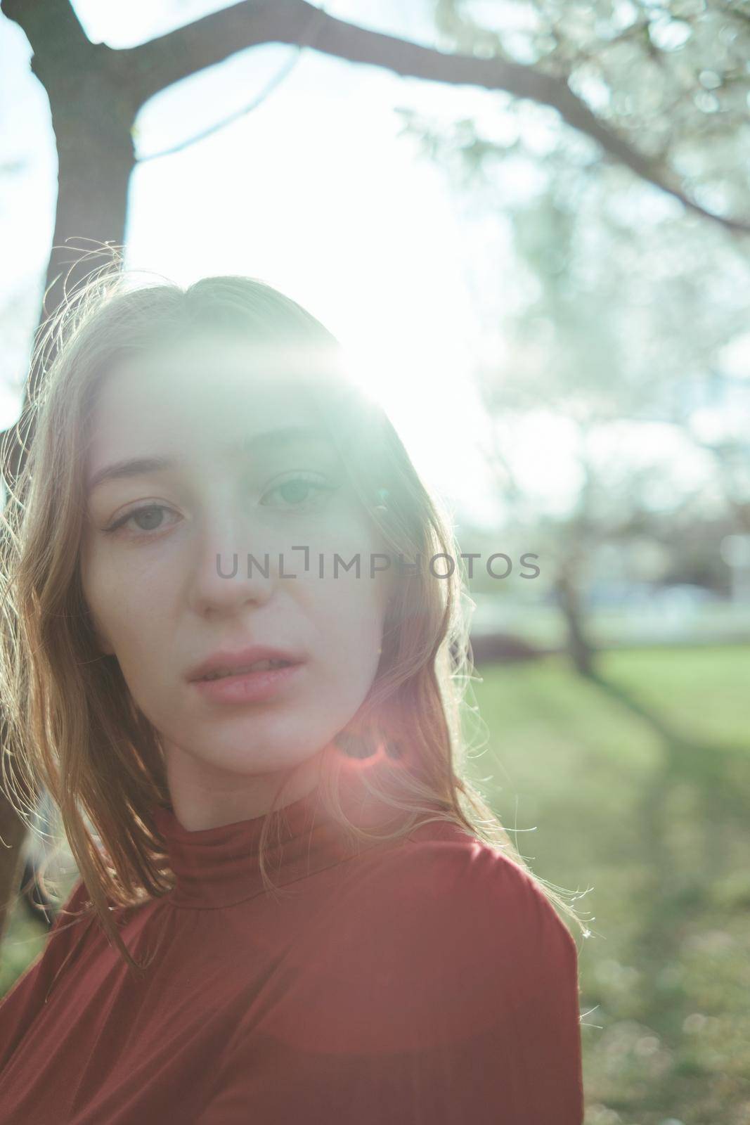 portrait of a girl in backlight in the park in the spring close-up by Symonenko