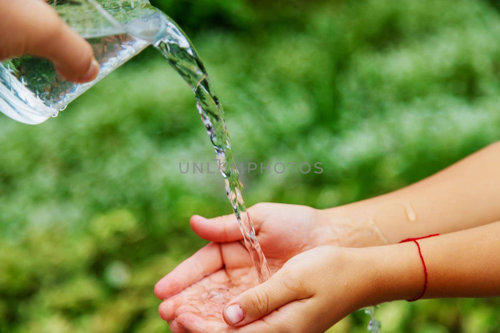 The child washes his hands in the street. Selective focus. nature