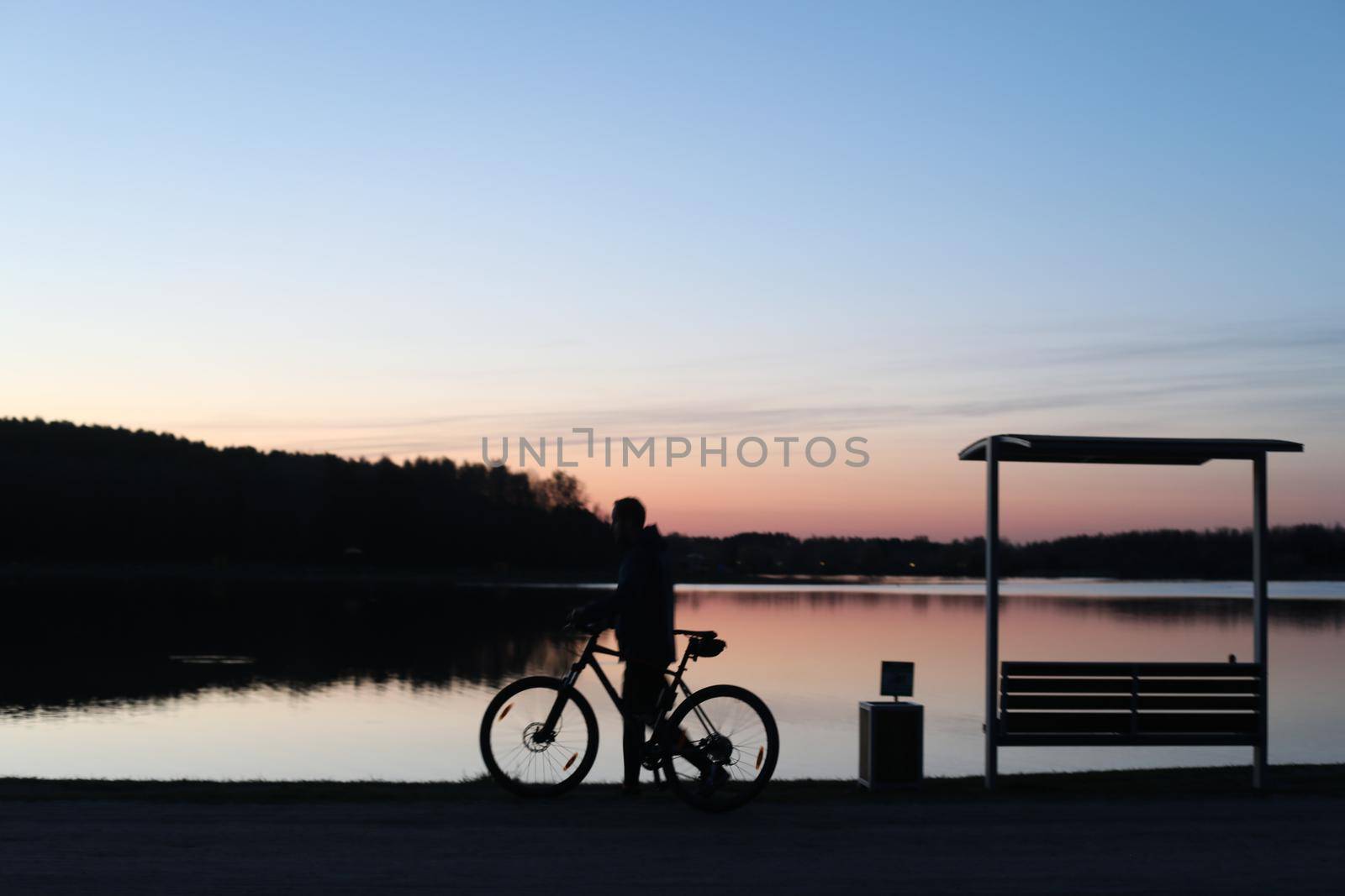 Silhouette of a cyclist on the beach at sunset.