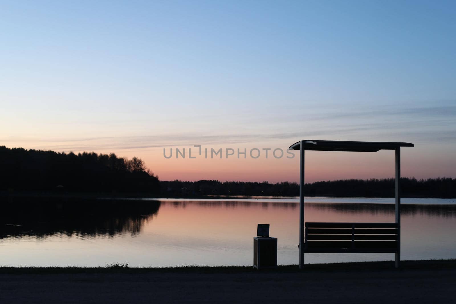 sunset at coast of the lake. Nature landscape. Reflection, blue sky and yellow sunlight. landscape during sunset.