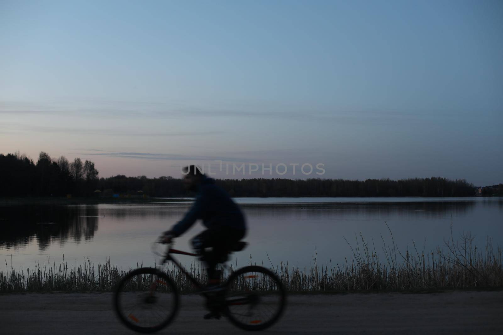 Silhouette of a cyclist on the beach at sunset.