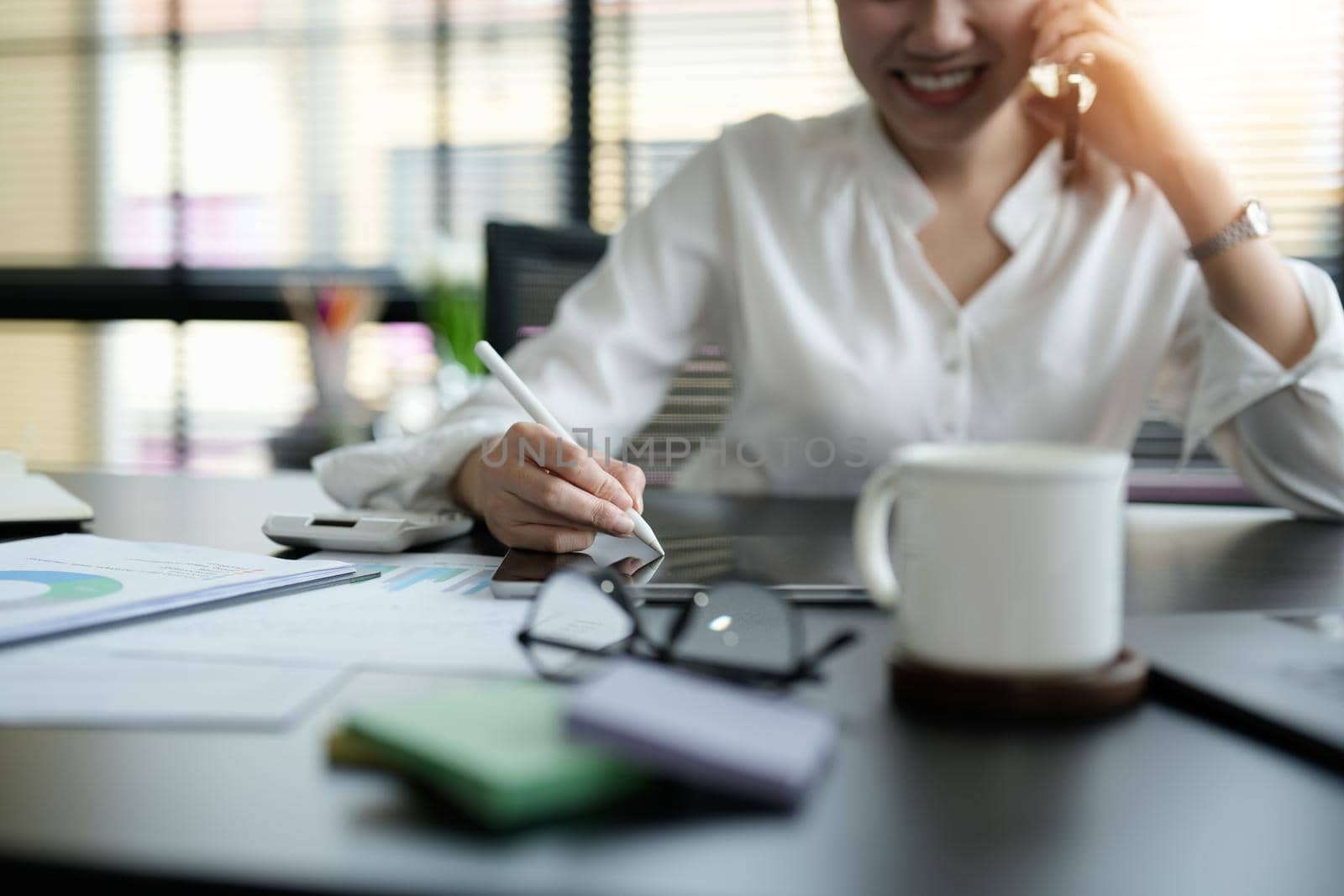 Close up business woman hand holding stylus pen and digital tablet for planning working schedule in office.