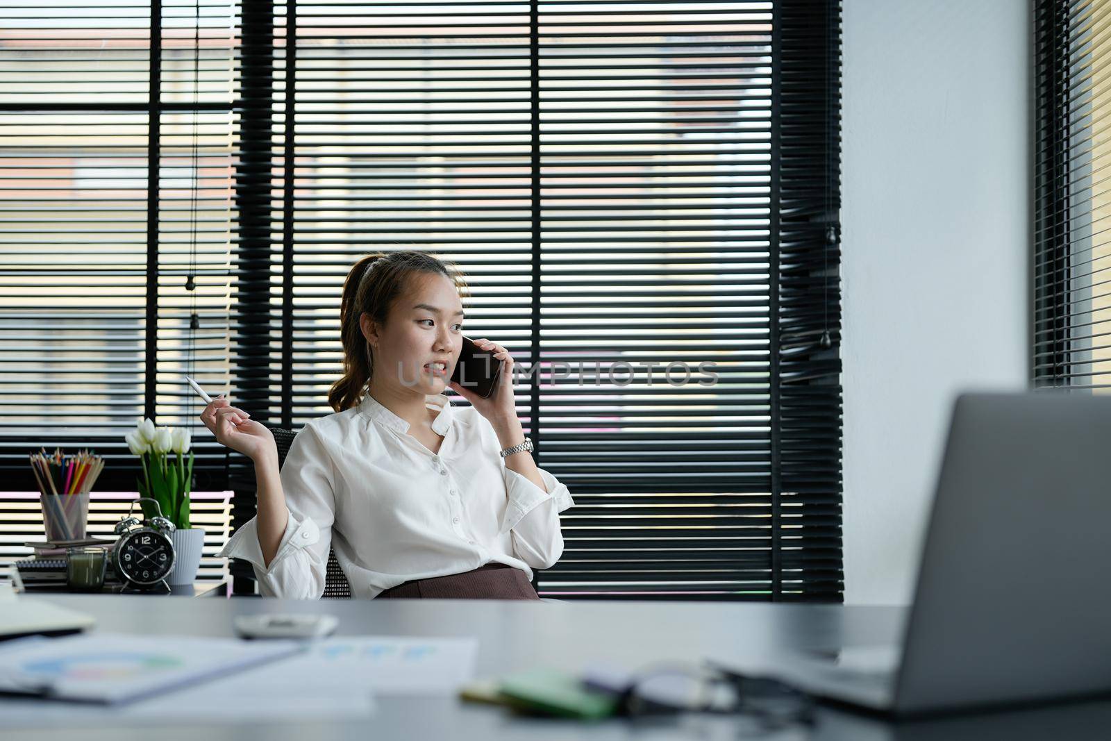 Portrait asian business woman making a phone call and smiling while working it office.
