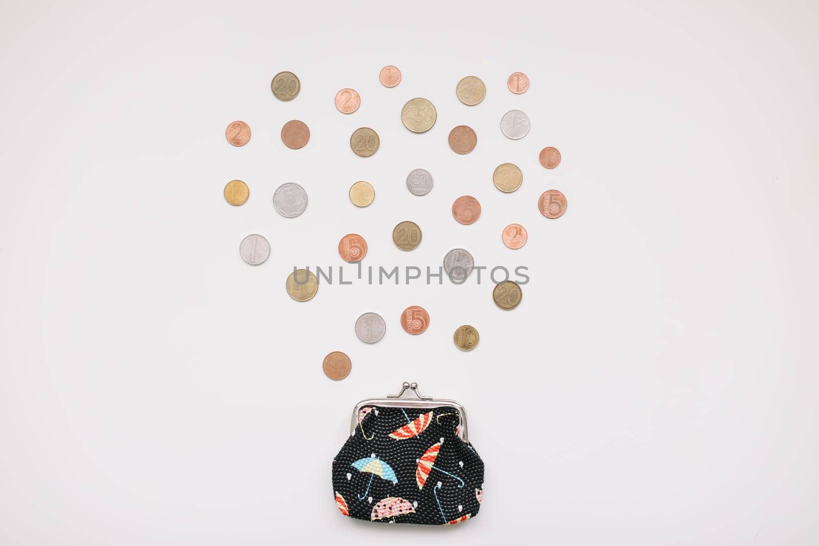 Open purse with different coins isolated on white background top view. Financial crisis, poverty, lack of money