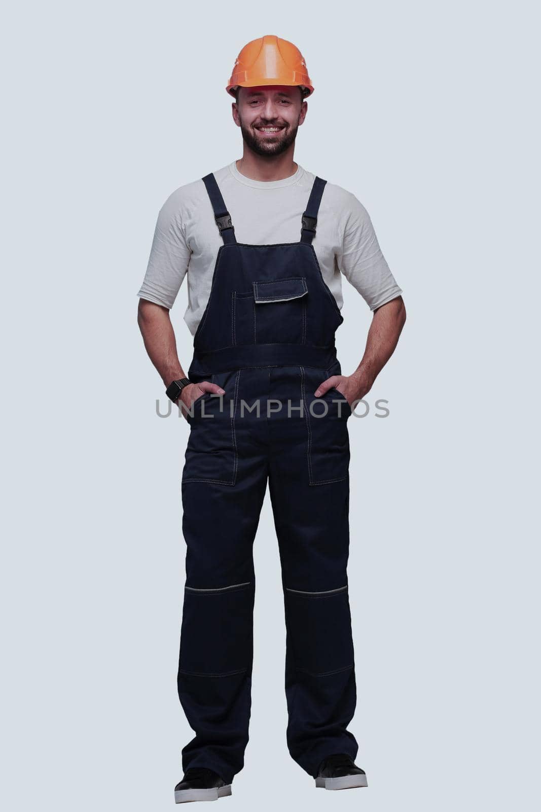 in full growth. confident man in overalls . isolated on white background