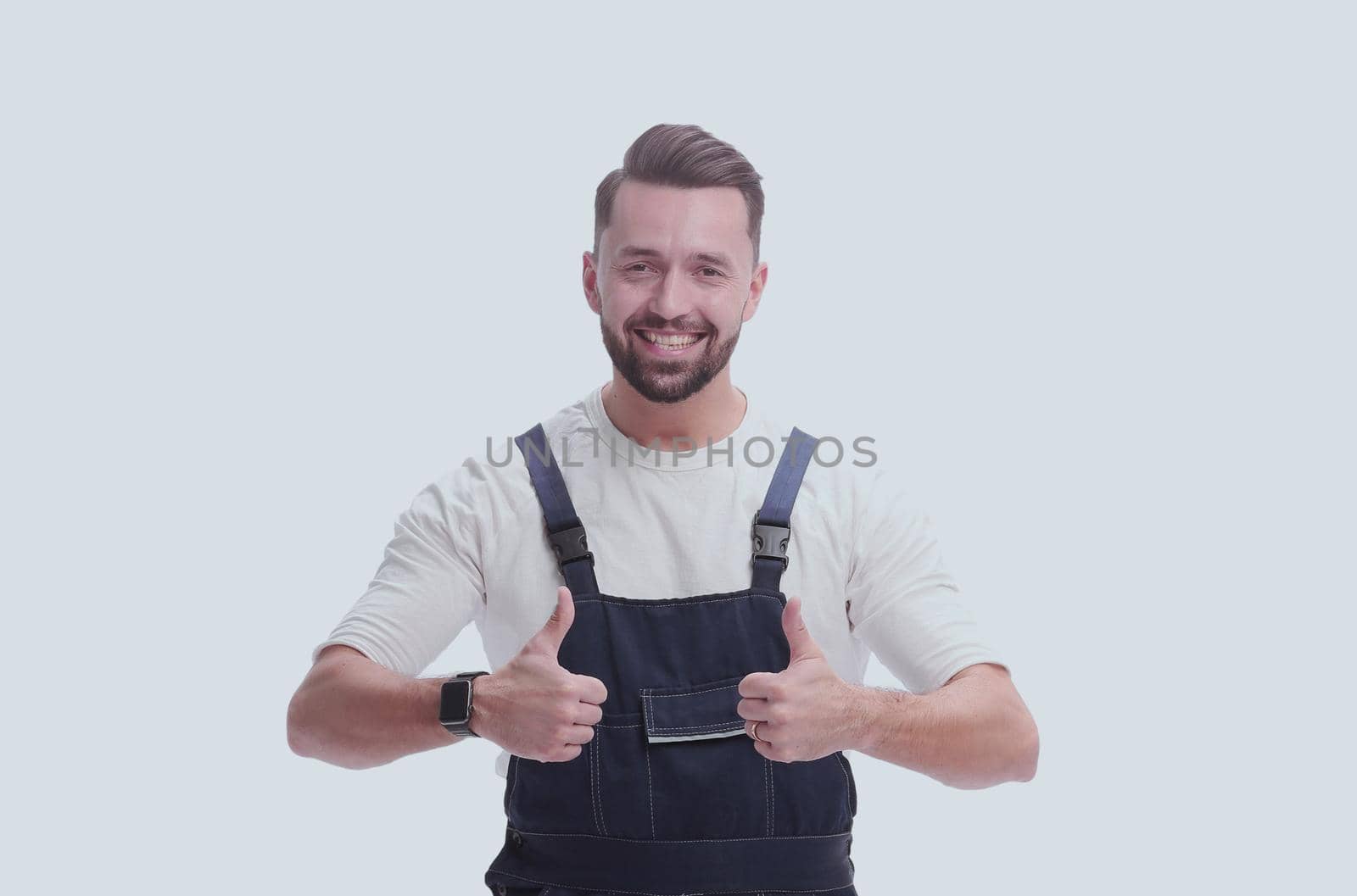 in full growth. friendly man in overalls showing thumbs up. isolated on white background