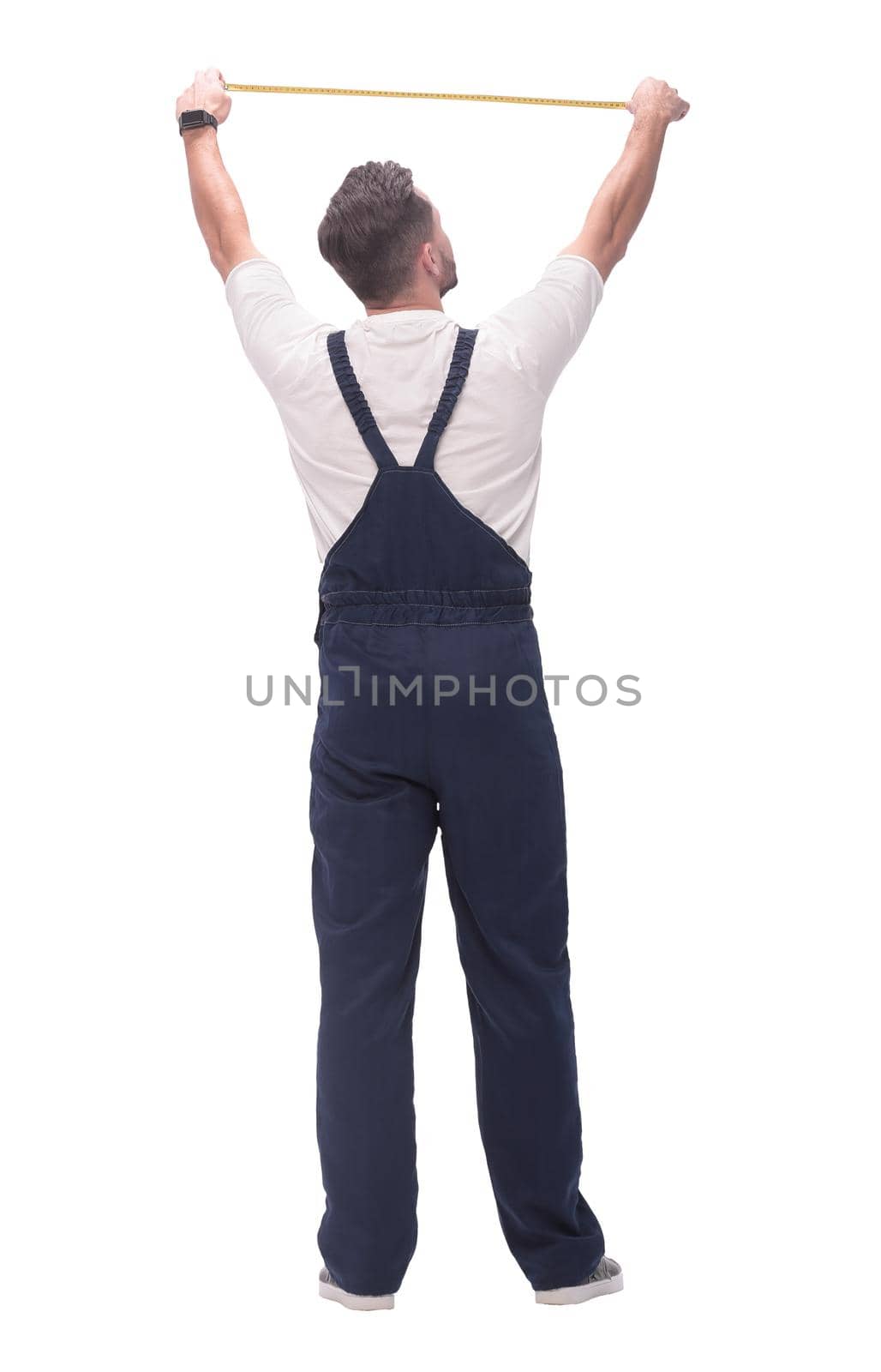 rear view. a man measuring something with a construction tape measure. isolated on white background