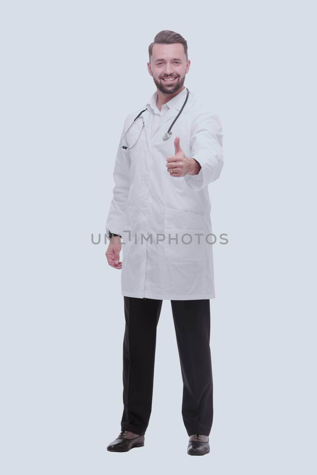 in full growth. smiling medical professional showing thumbs up .isolated on white background