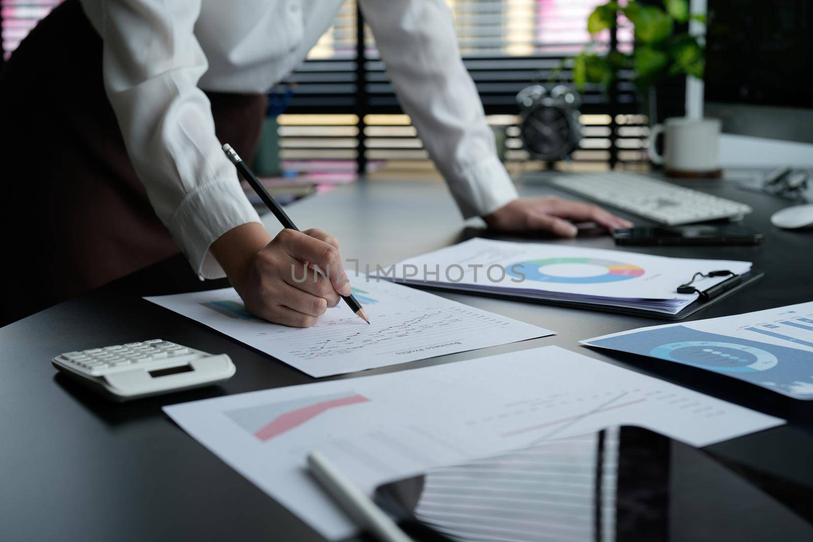 Business woman using calculator for do math finance on wooden desk in office and business working background, tax, accounting, statistics and analytic research concept.